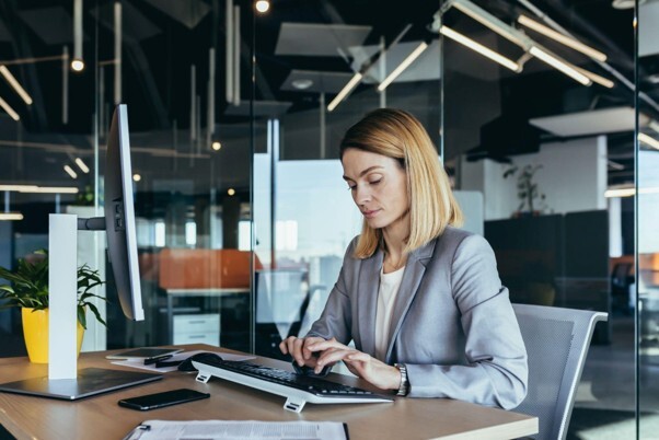 Employer reviewing right to work compliance and recruitment records on a laptop in a modern office.